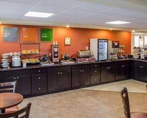 A breakfast bar with various food items and a coffee machine.