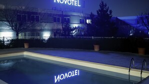 Un hotel Novotel con una piscina en primer plano.