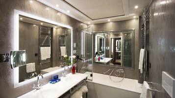 A modern bathroom with a large mirror, a white sink, and a bathtub.