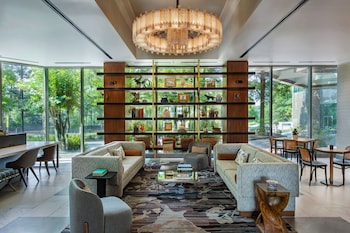 A modern cafe with a large window view, a counter with pastries, and a display of bottled drinks. at JW Marriott Atlanta Buckhead