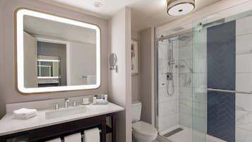 Een moderne badkamer met een grote spiegel, een wastafelmeubel met een wastafel, een toilet en een douchecabine.