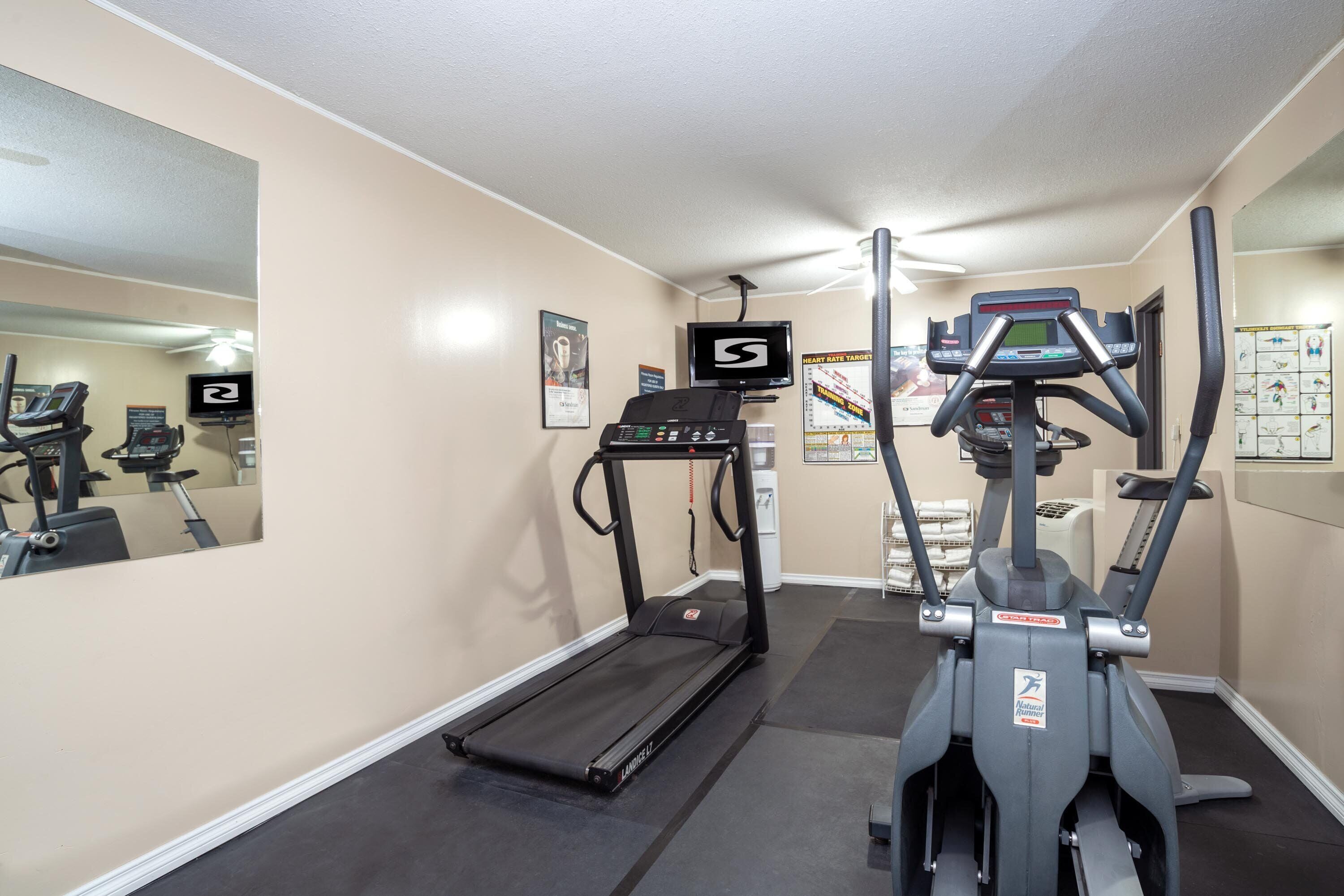 A gym with treadmills, an elliptical, and a stationary bike.