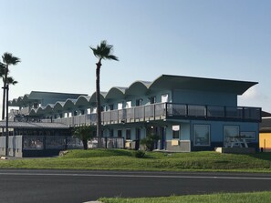 A modern hotel with a multi-story structure, balconies, and a flat roof. - Blue Wave Inn (Rockport)