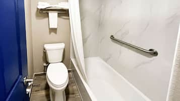 A bathroom with a toilet, a shower with a grab bar, and a towel rack.