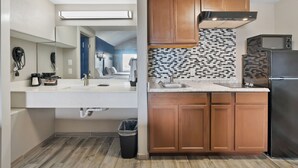 Una cocina moderna con armarios de madera, un refrigerador de acero inoxidable y un salpicadero de azulejos.