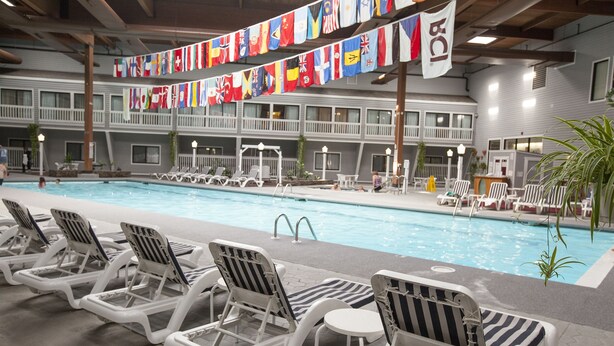 Un espace piscine avec des chaises longues et des drapeaux.