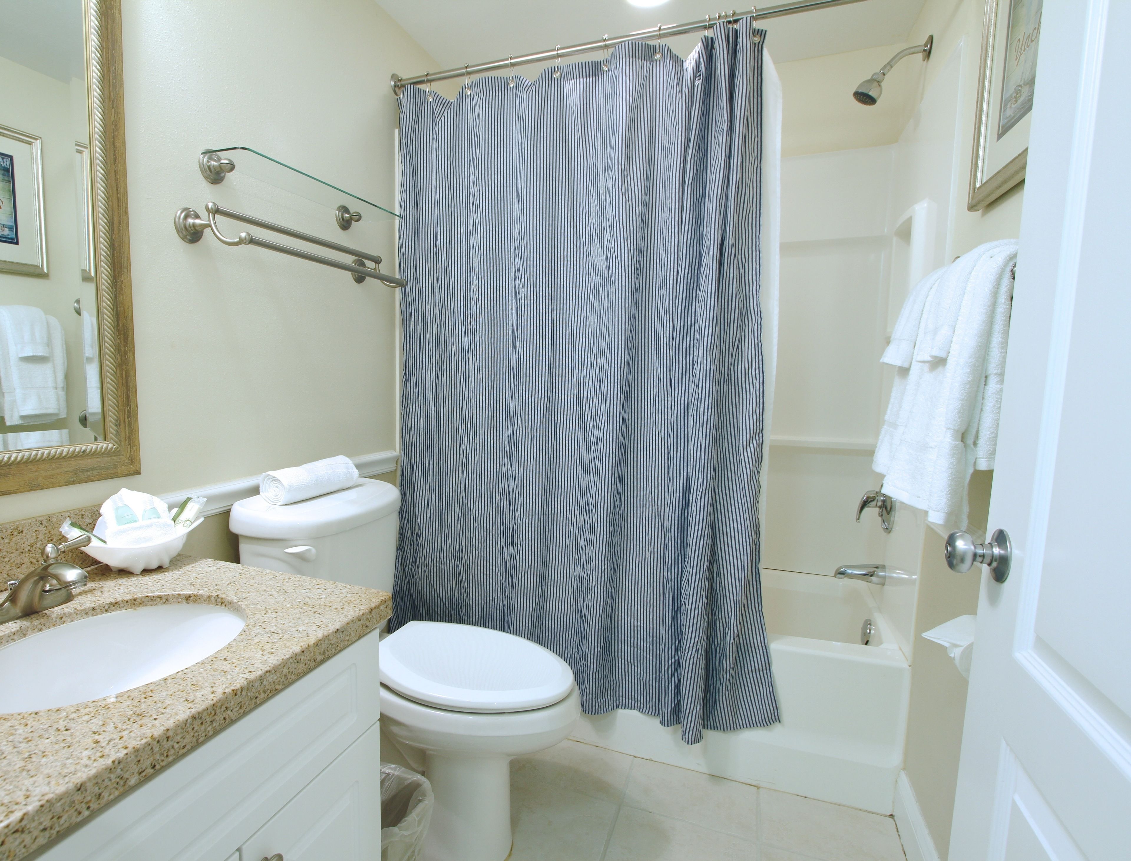 A bathroom with a sink, toilet, bathtub, and shower curtain.