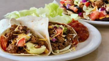 A plate with two tacos and a side salad.