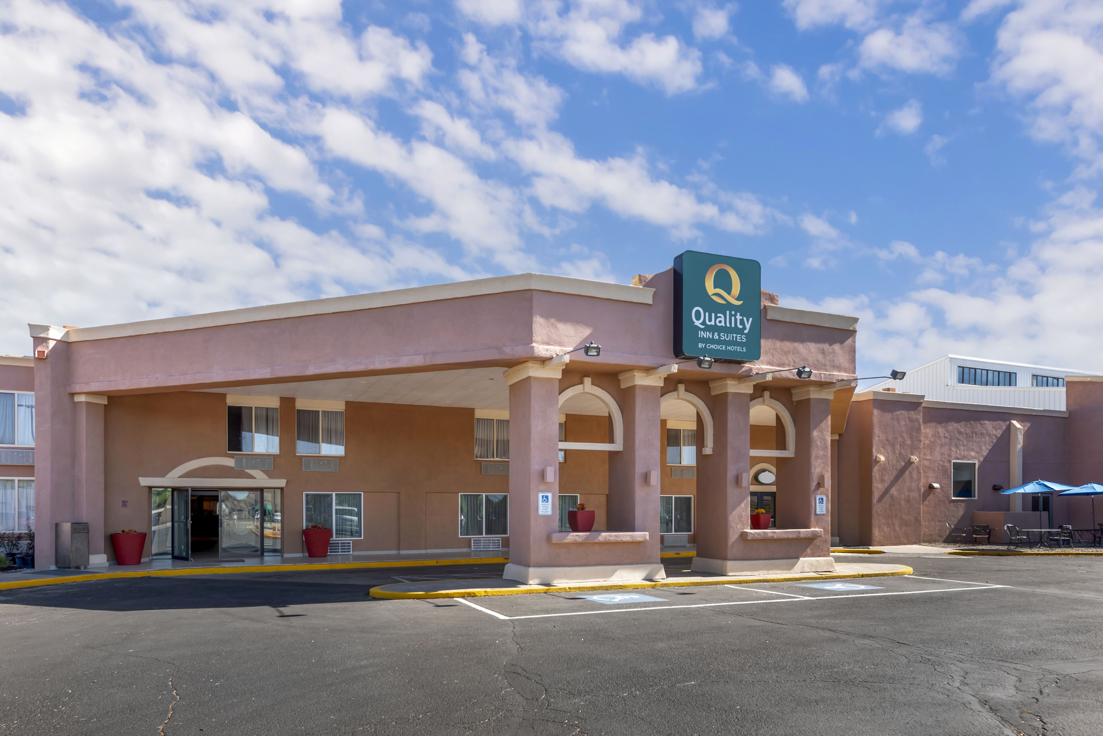 Een hotel met een bord waarop staat: Quality Inn & Suites by Choice Hotels.