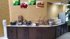 A breakfast bar with a coffee machine, a waffle maker, and a coffee dispenser.