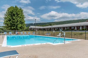 Piscina a l'aire lliure de temporada, para-sols i gandules 