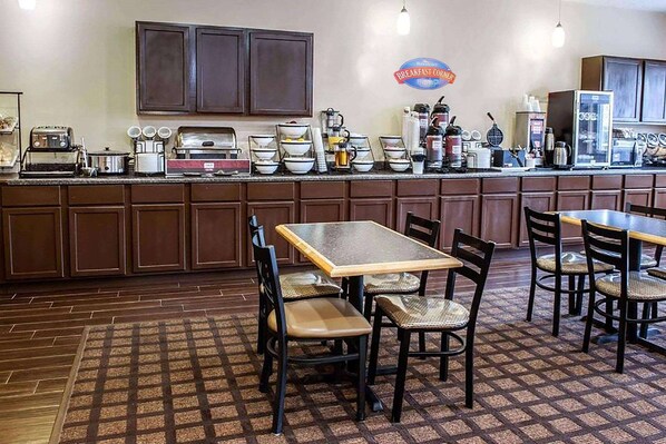 A breakfast cafe with a long counter, wooden cabinets, and a tiled floor.