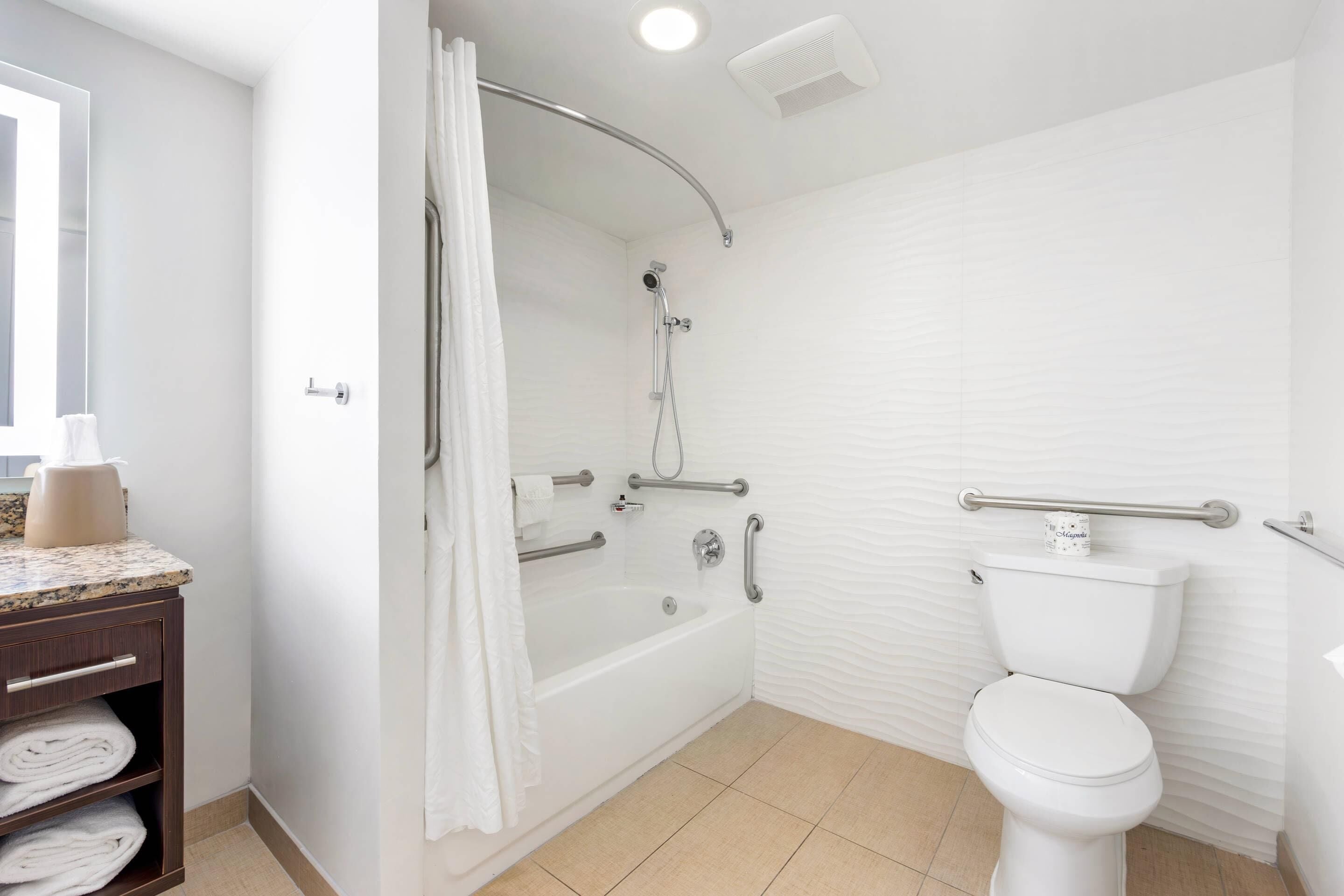 Un baño moderno con bañera, inodoro y ducha.