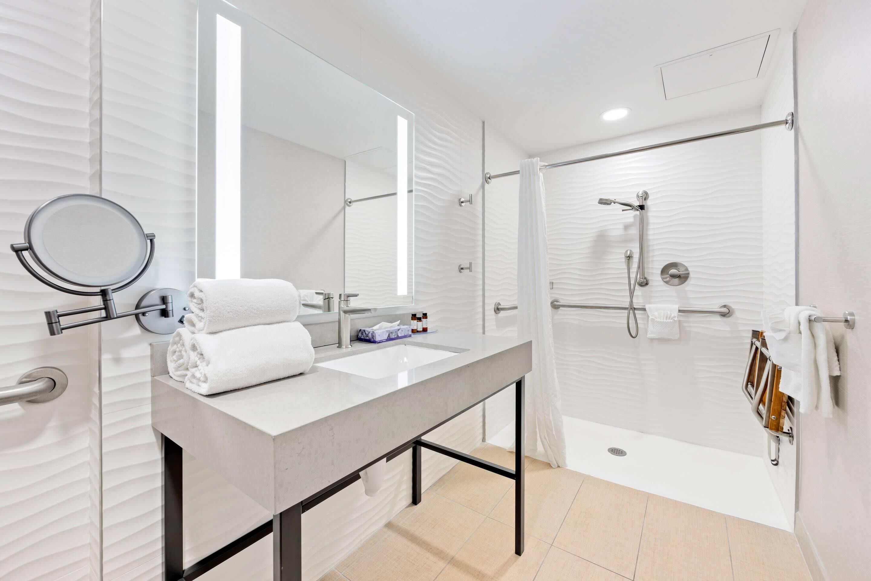 A modern bathroom with a vanity, a shower, and a toilet.
