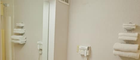 A bathroom with a sink, mirror, towel rack, and toilet.