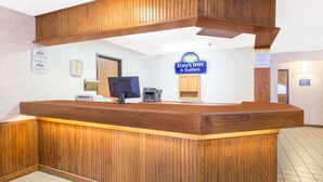 Una recepción con detalles de madera, un monitor de computadora y un letrero de Days Inn & Suites.