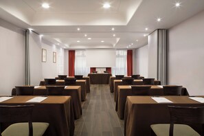 A conference room with tables, chairs, and a podium.
