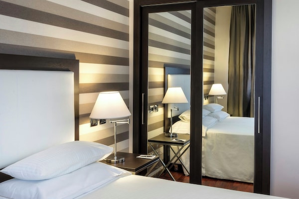 Deluxe kamer | Een minibar, een kluis op de kamer, een bureau, geluiddichte muren