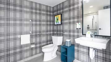 A modern bathroom with a plaid-patterned wall, a toilet, a sink, and a mirror.