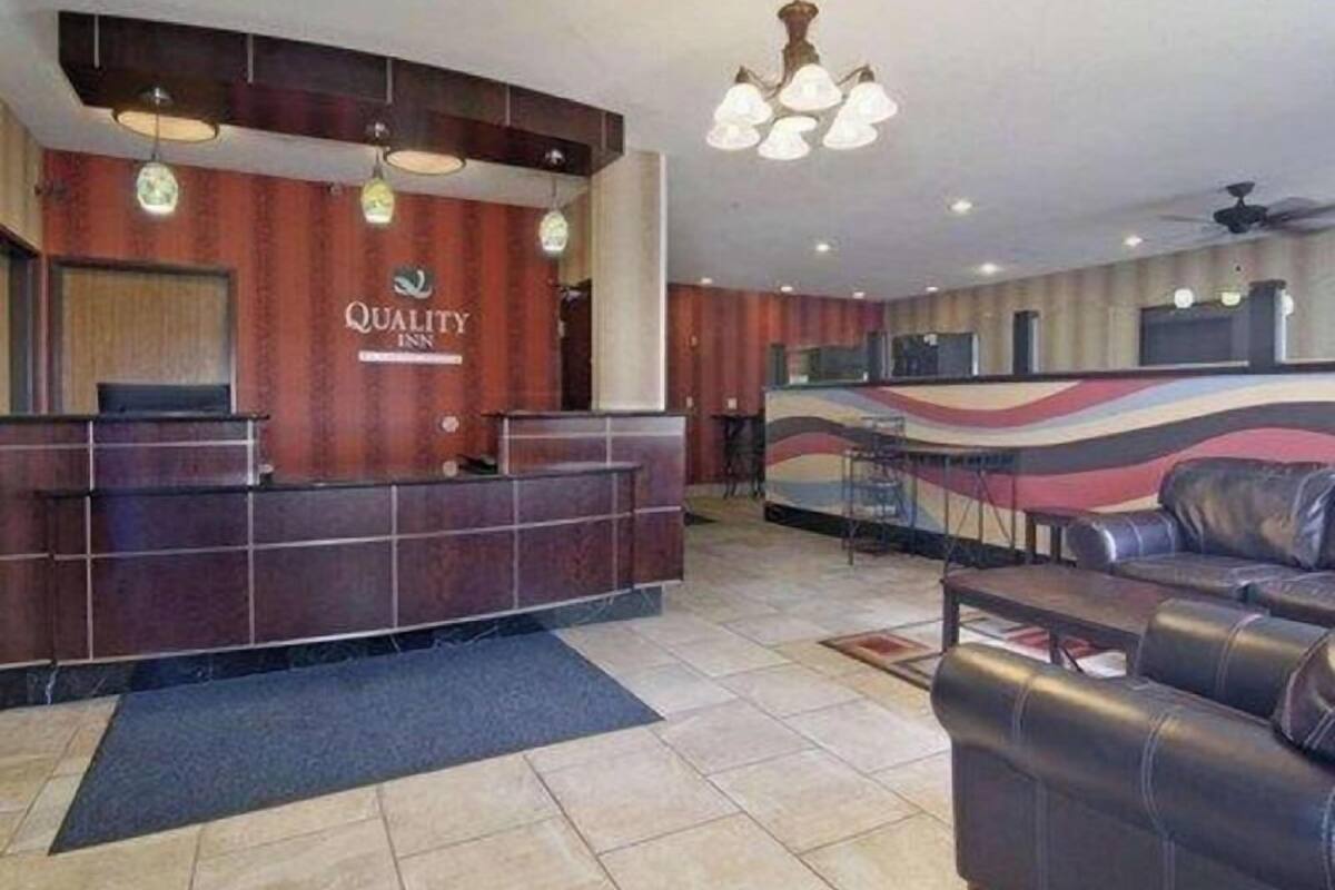 A hotel reception area with a reception desk, a bar, and a seating area.