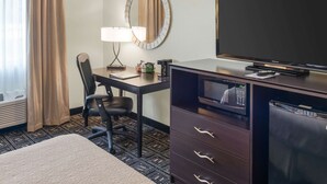 A hotel room with a bed, a desk with a chair, a television, a microwave, and a refrigerator. - Quality Inn & Suites Mankato East (Mankato)
