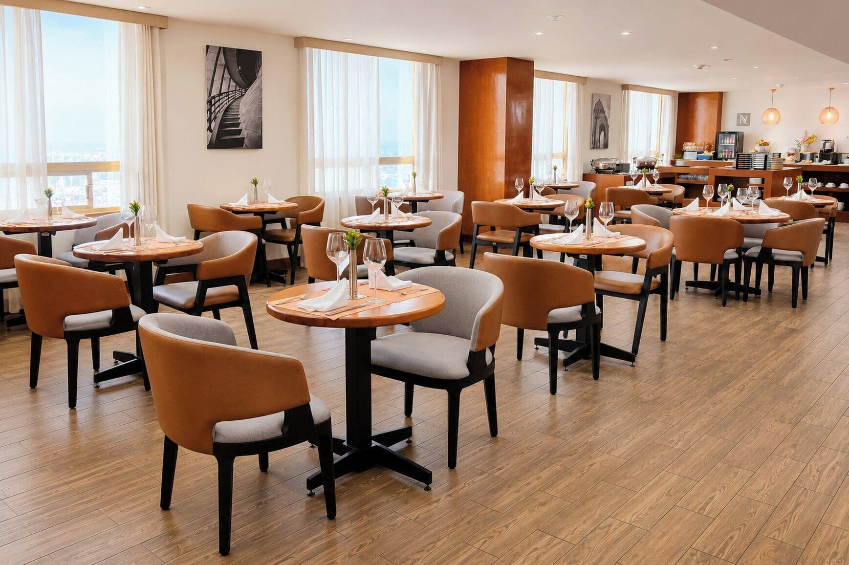 A modern dining area with round tables, cushioned chairs, and large windows.