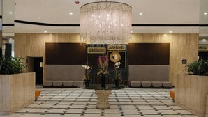 A lobby with a chandelier, a reception desk, and a patterned floor. - Fiesta Americana Reforma (Mexico City)