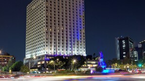 A high-rise hotel with a modern design, featuring a prominent entrance and a statue in front. - Fiesta Americana Reforma (Mexico City)