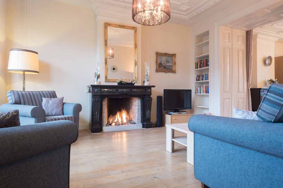 Ein Wohnzimmer mit Kamin, Fernseher und Bücherregal.
