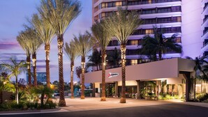 A modern hotel with a flat facade, palm trees, and a well-lit entrance. - Irvine Marriott (Irvine)