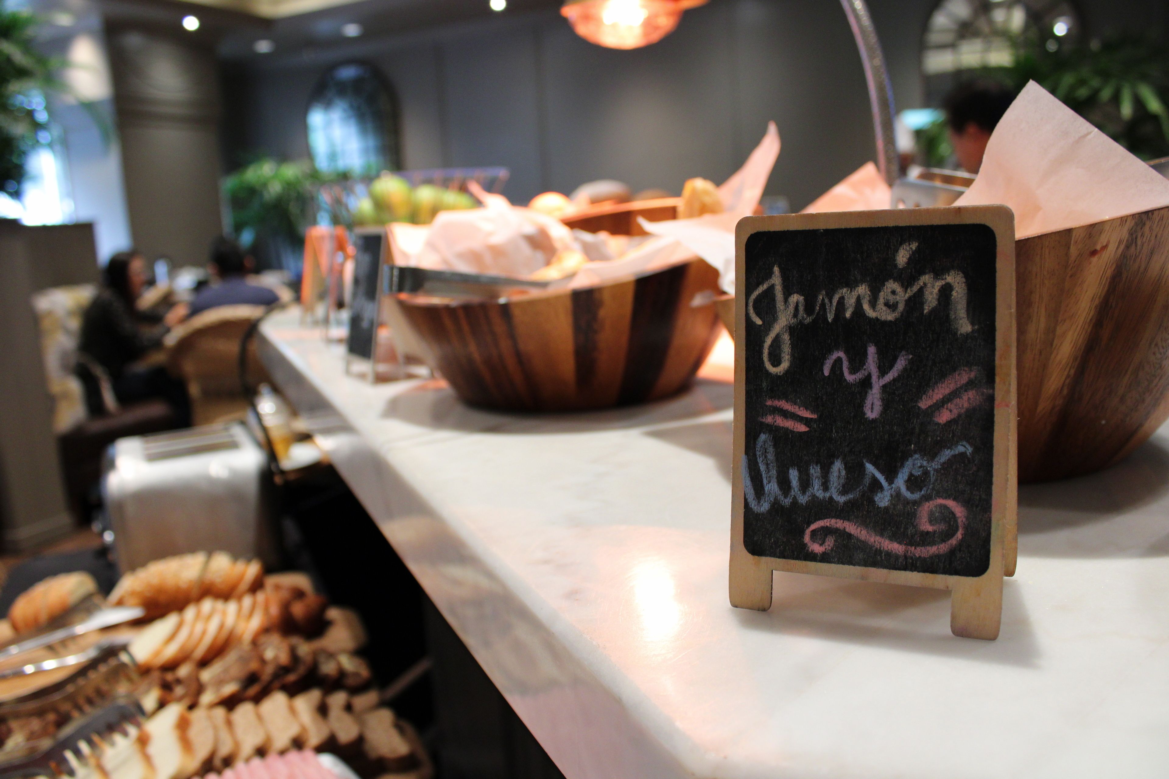 A buffet area with various food items and a chalkboard sign.