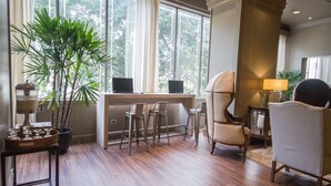A room with a desk, two chairs, a potted plant, and a lamp. - Unipark by Oro Verde Hotels (Guayaquil)