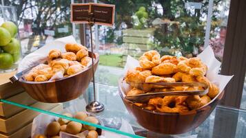 A display of pastries in a bakery window with a sign indicating chocolate and natural croissants.