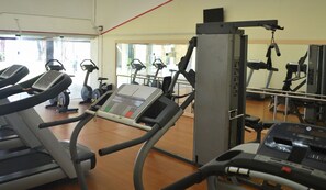 A gym with treadmills, elliptical machines, and a weight machine.