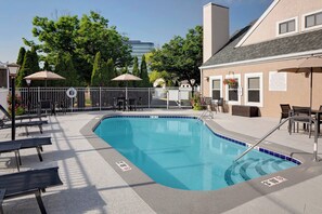 A swimming pool with lounge chairs and umbrellas, surrounded by a white fence and trees. - Residence Inn by Marriott Louisville East (Louisville)