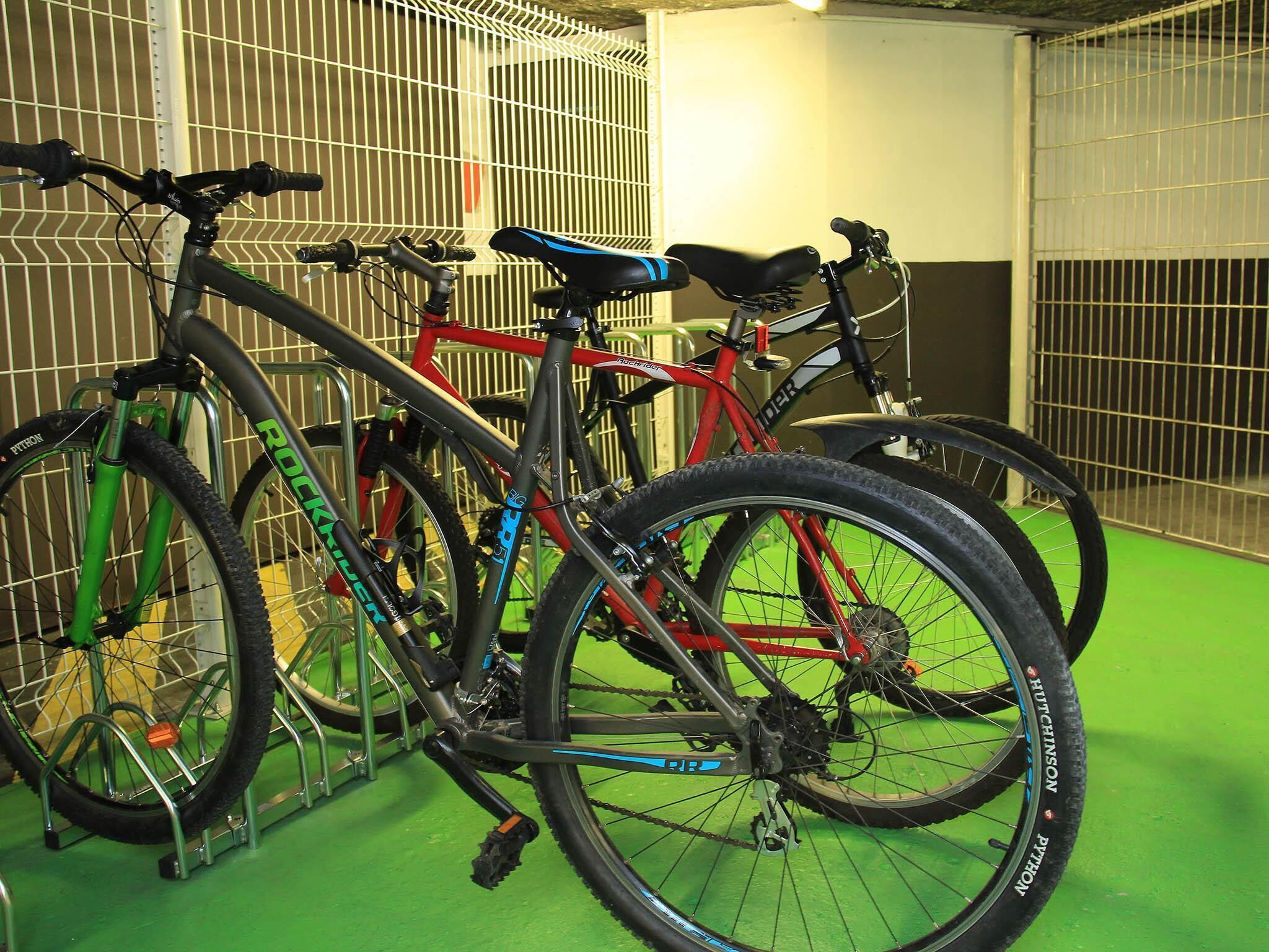 A bicycle rack with three bicycles secured to it.