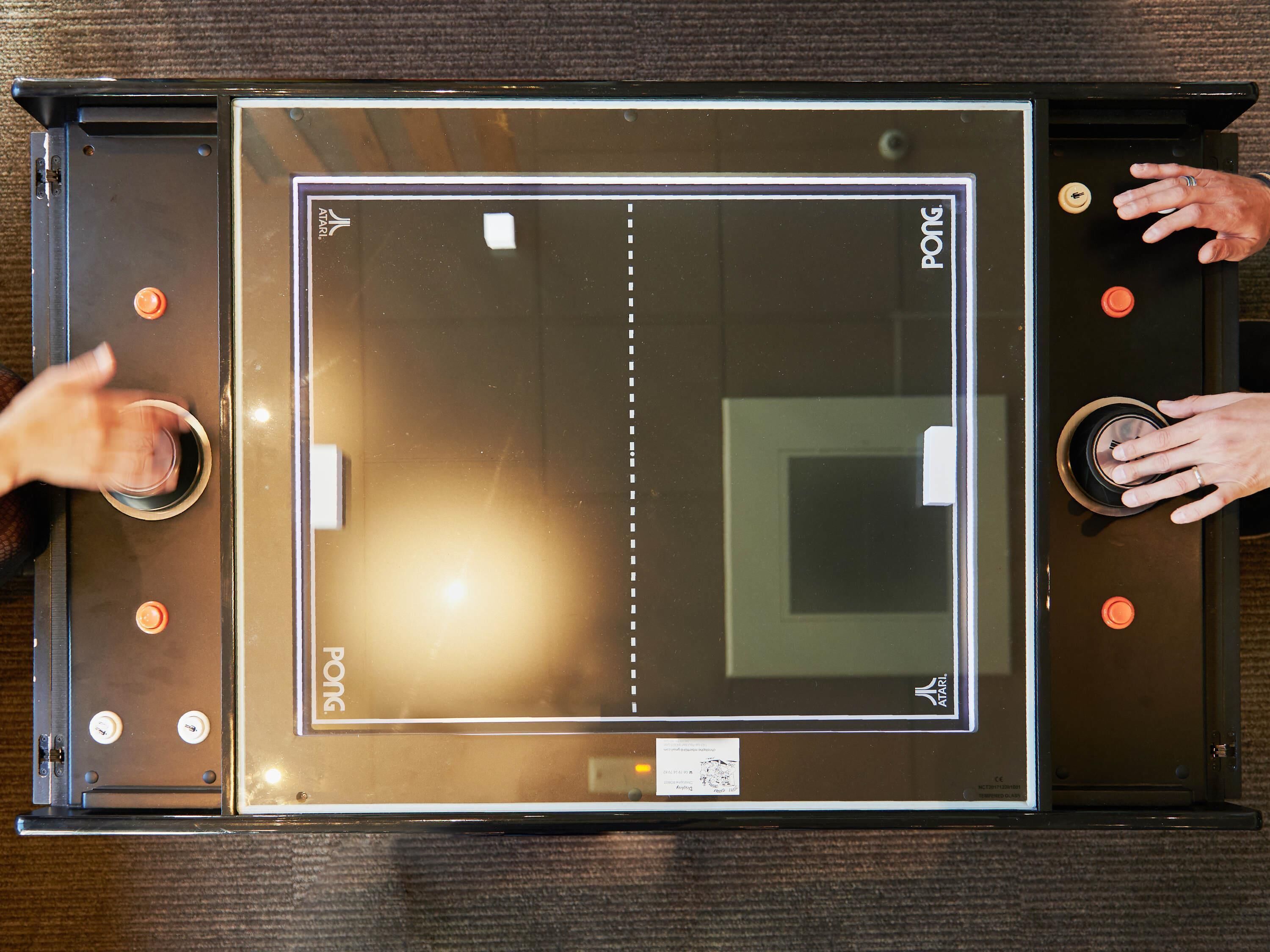 A view of a room with a large window, a door, and a control panel with buttons.