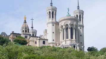 A large, ornate church with multiple spires and domes, surrounded by lush greenery.