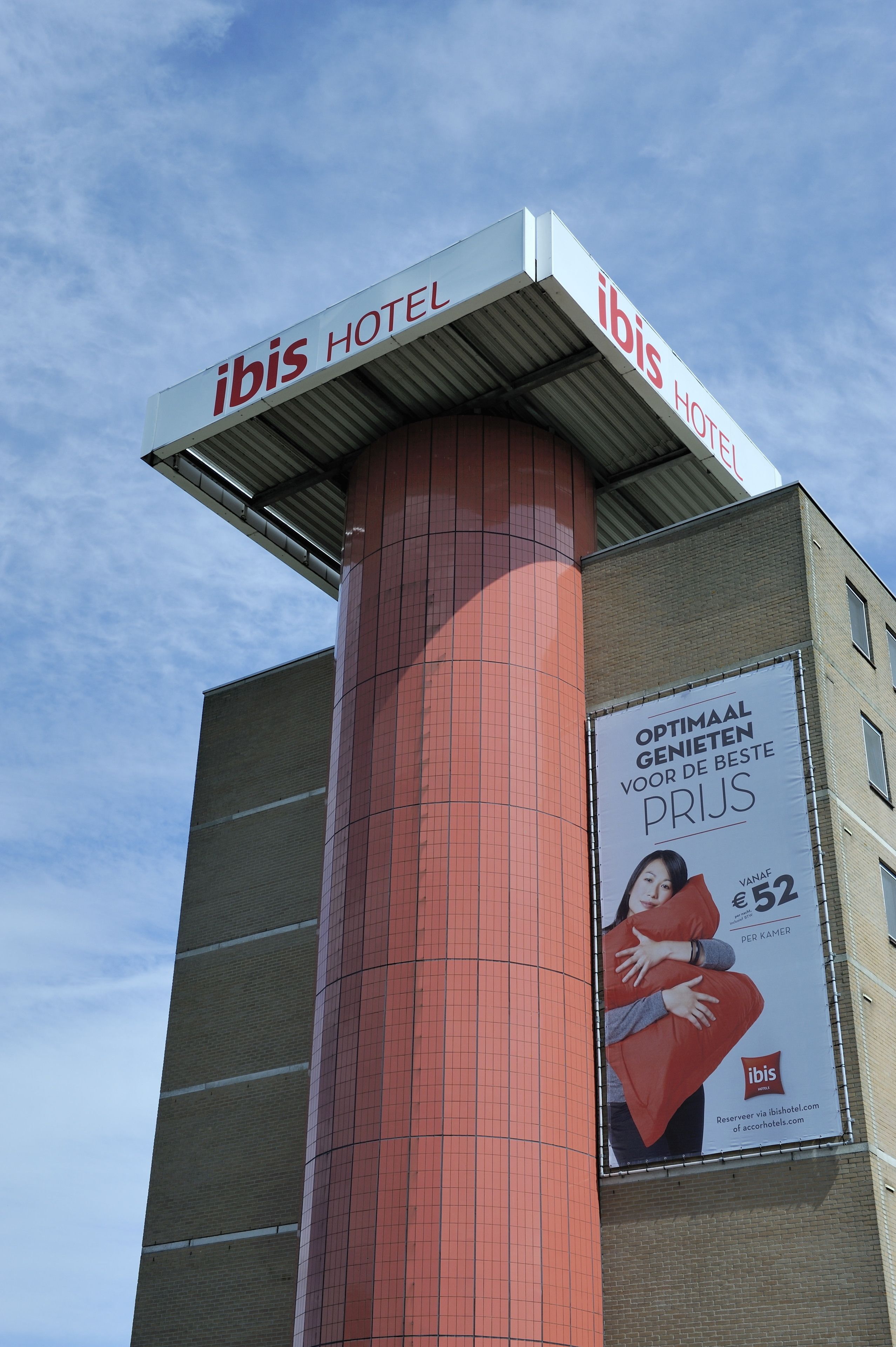 El exterior del hotel ibis, con un cartel llamativo y un gran anuncio.