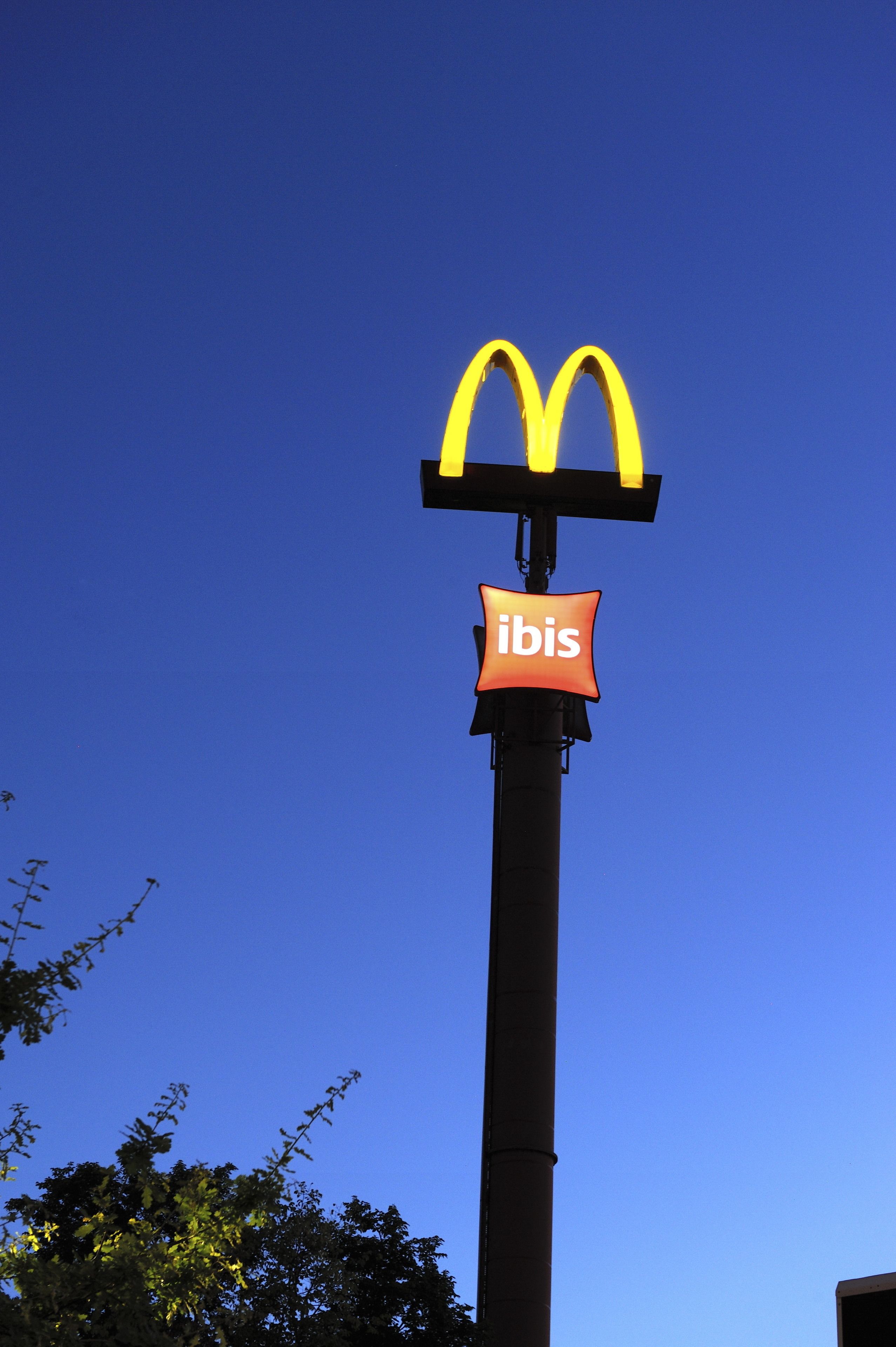Een McDonald's bord met een 'ibis' logo op een paal.