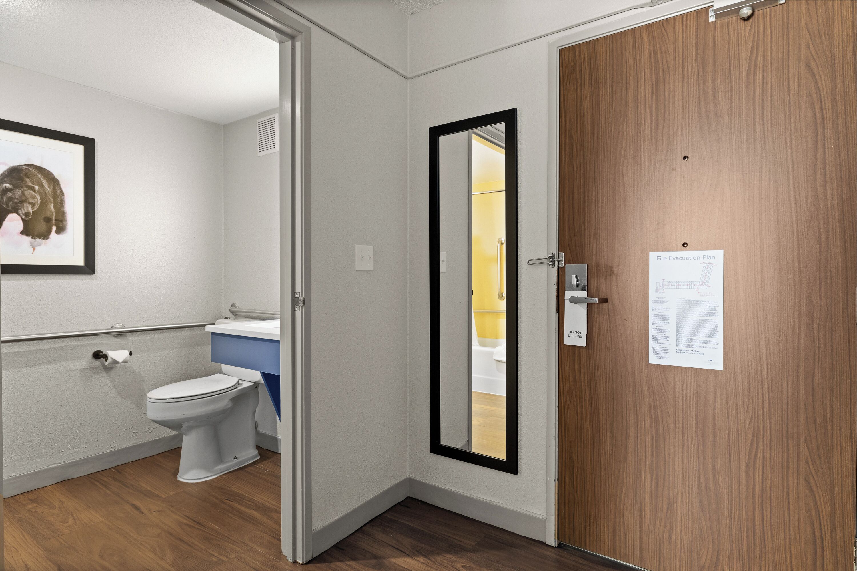 A bathroom with a toilet, sink, and mirror.