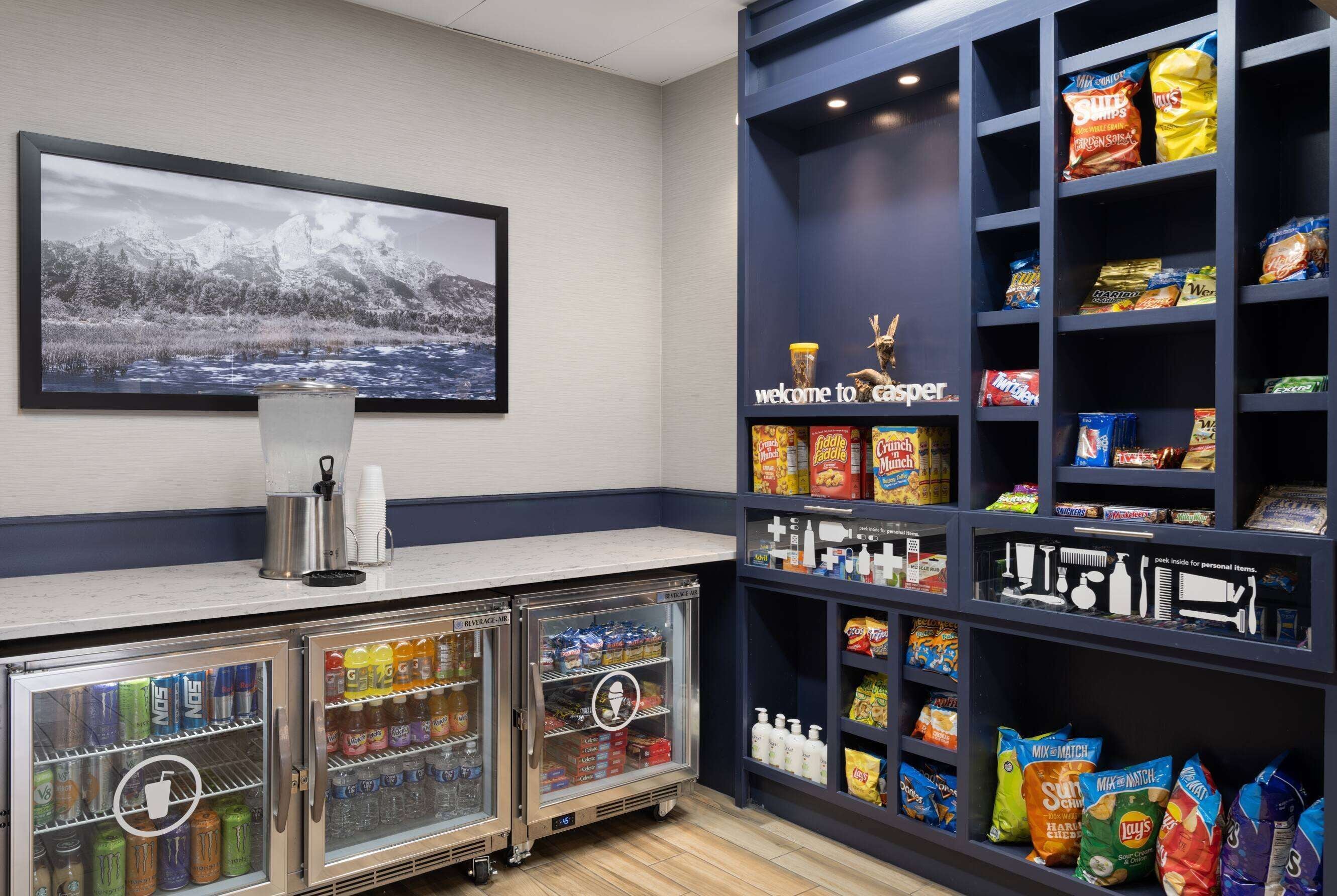 A snack bar with a variety of snacks and beverages, a refrigerator with drinks, and a welcome sign.