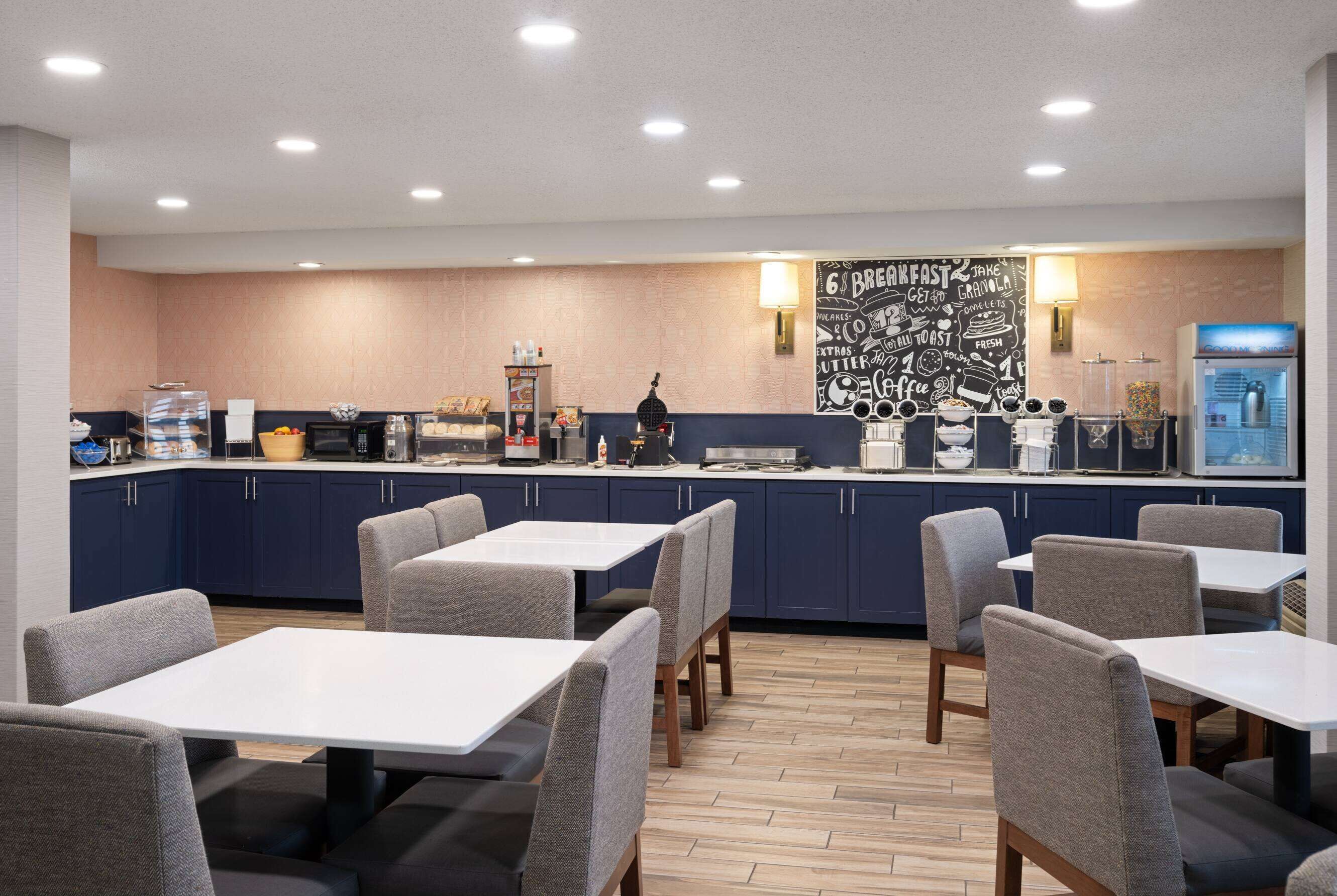 A modern breakfast area with a counter, seating, and a wall with breakfast-related graphics.