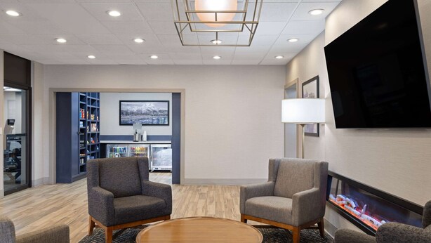 A modern lounge area with a flat-screen TV, comfortable seating, and a fireplace.