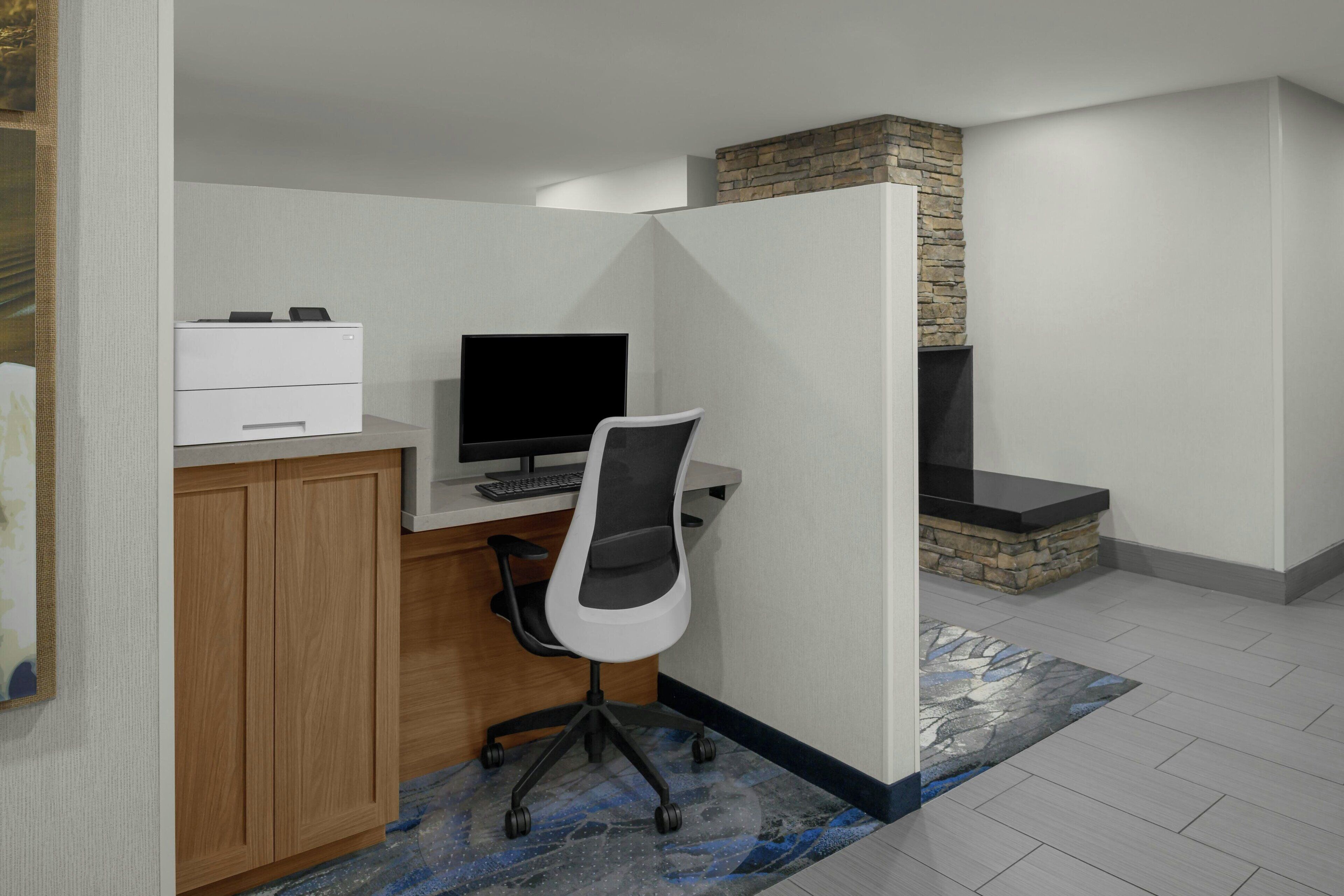Un bureau à domicile équipé d’un bureau, d’un ordinateur et d’une imprimante.