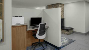 Un bureau à domicile équipé d’un bureau, d’un ordinateur et d’une imprimante.