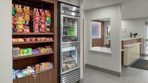 Una presentación de bocadillos con diversos alimentos envasados y una sección refrigerada con bebidas.