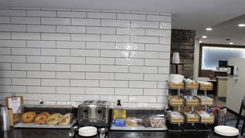 A breakfast buffet with various food items, a toaster, and a coffee machine.