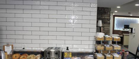 Un buffet de petit-déjeuner proposant divers aliments, un grille-pain et une machine à café.