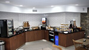 Una cocina moderna con refrigerador, microondas y cafetera integrados.